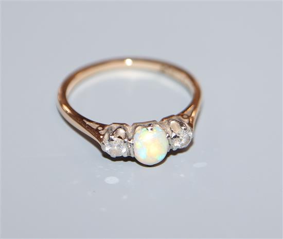An 18ct and plat, white opal and diamond three stone ring, size K/L.